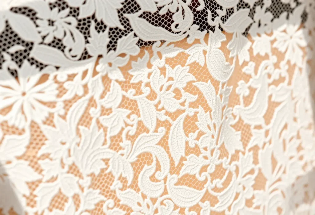 Prise rapprochée sur la dentelle avec ses motifs complexes, mettant en valeur la beauté et le travail artisanal du body.